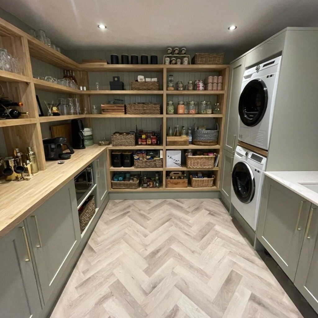 Utility room combining a pantry with open shelving and stacked white laundry machines.