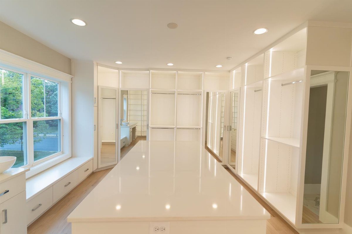 White walk-in closet with a central island and recessed ceiling lighting.