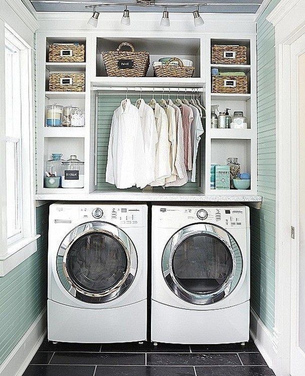 Side by side white washer and dryer under white laundry room shelving
