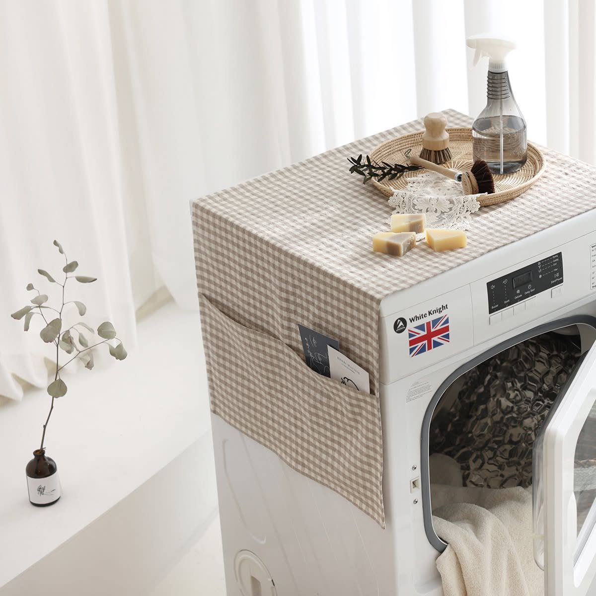Gingham fabric cover on a white washing machine with cleaning supplies on top