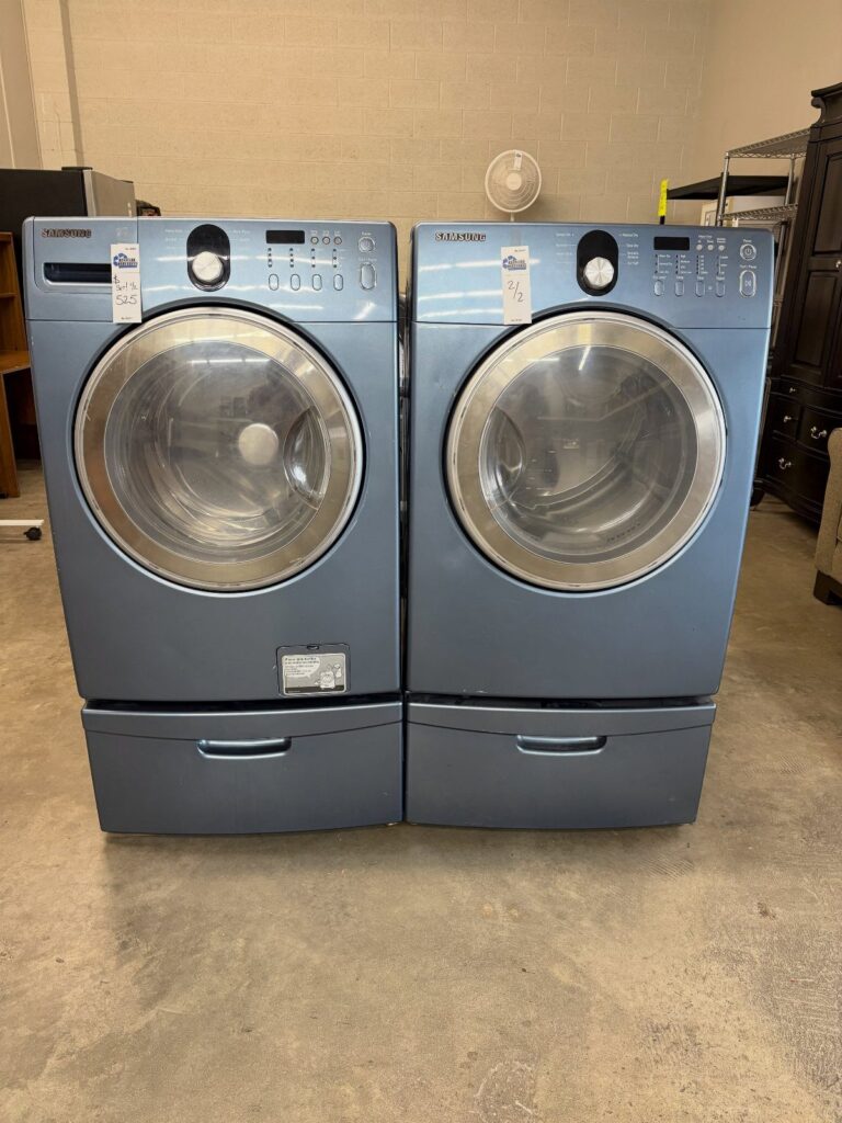 Blue Samsung washer and dryer set elevated on pedestals with pull-out drawers.