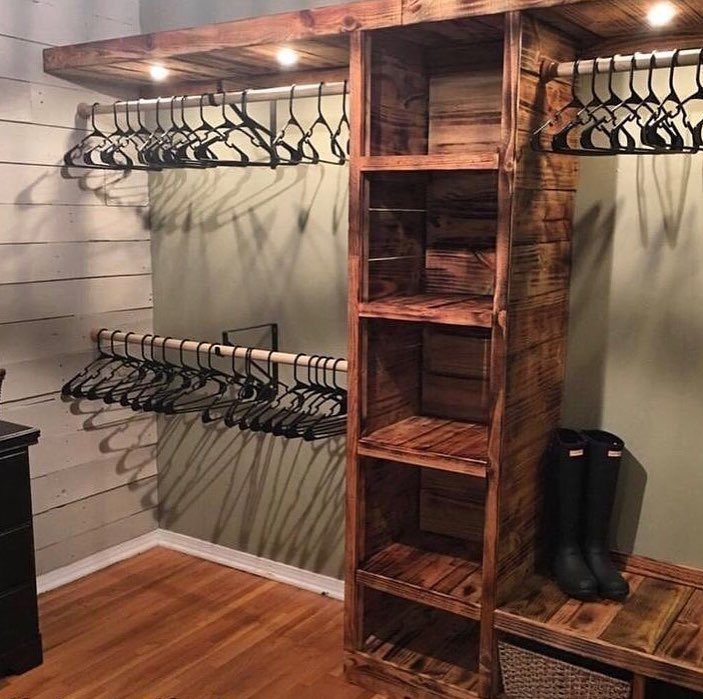 Rustic wooden closet system with built-in shelves, hanging rods, and a storage bench.